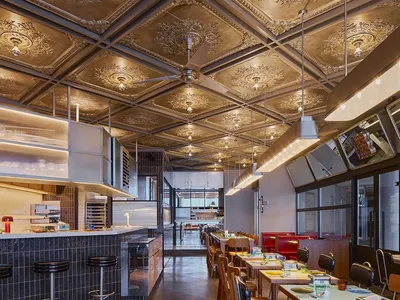 現代商用廚房附用餐區，設有桌椅、電器設備及散置瓶子，位於餐廳或商用廚房環境