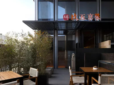 溫馨餐廳室內，設有桌椅、吧台、盆栽與亞洲風格壁飾