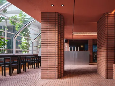 紅磚牆溫馨餐廳內部，磁磚地板，餐桌周圍環繞座椅與酒瓶
