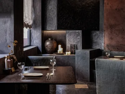 Warm and inviting restaurant interior with wooden tables, chairs, and a kitchen in the background