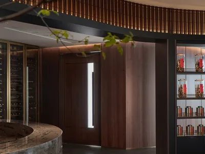 Modern interior design showroom with wooden flooring, wine bottles, and wine glasses, creating a sophisticated atmosphere