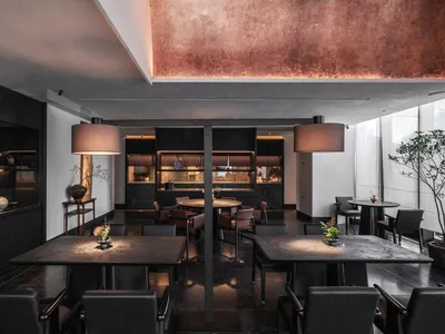 Sophisticated restaurant interior with multiple dining tables, wood paneling, and warm lighting
