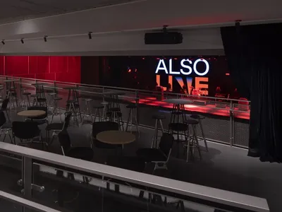 Modern restaurant interior with multiple dining tables and chairs, couches, and a welcoming atmosphere
