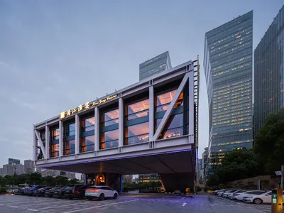 A modern hotel lobby with a prominent glass facade, multiple floors, and a contemporary design