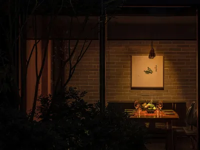 溫馨亞洲風餐廳區，磚牆、餐桌與椅子，搭配酒杯與溫暖氛圍