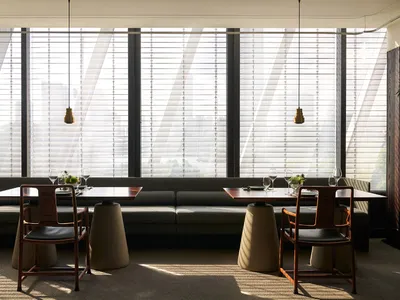 Bright modern restaurant interior with natural light, dining tables, and chairs