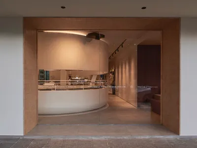 餐廳內部擁有環形用餐區、弧形牆面，以及環繞大型餐桌的座椅，營造溫馨氛圍