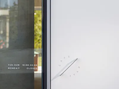 A clean and well-organized hotel lobby entrance with a white door, two clocks, and a sense of modernity