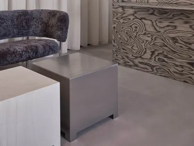 Elegant showroom with a display case filled with vases, bowls, and bottles, accompanied by two chairs and a dining table