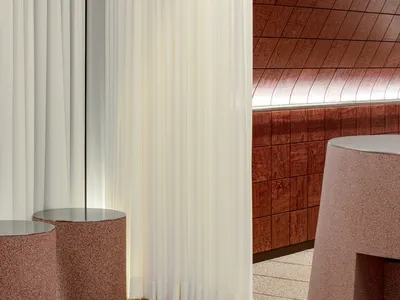 A large room with marble flooring, featuring three round tables and benches, in a modern and elegant atmosphere