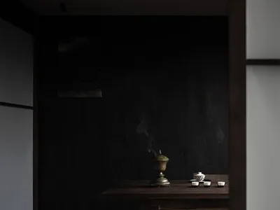燈光柔和的餐廳，配有深色木桌、兩碗食物、杯子和花瓶，營造溫馨親密的氛圍