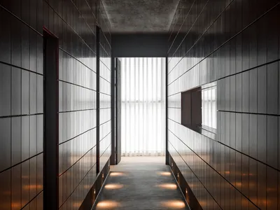 A calm and quiet hotel hallway with a wooden floor, illuminated by lights on both sides, and two doors at either end
