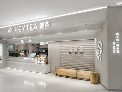 A clean and inviting Asian restaurant with a white interior, featuring a counter and dining area with chairs and tables, and cups on surfaces