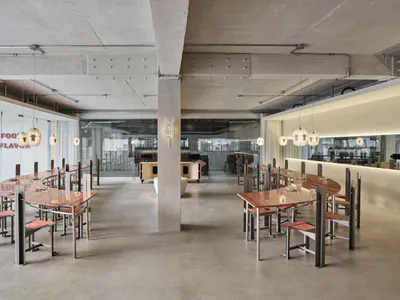 Industrial restaurant with multiple dining tables and chairs, modern and functional design for efficient space use