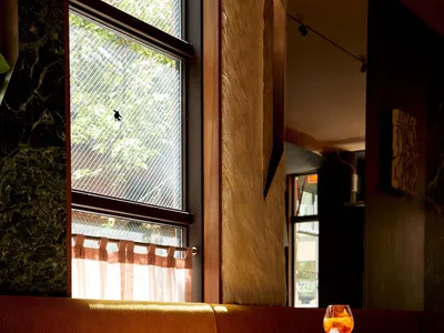 溫馨餐廳內部，設有木製長椅、餐桌與酒杯，營造舒適氛圍