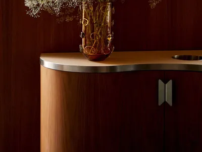 A vase with white flowers on a wooden table in a cozy living area