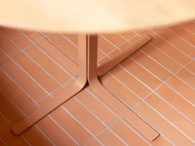 A wooden dining table sits on a patterned tile floor in a warm and inviting room, perfect for gatherings and meals