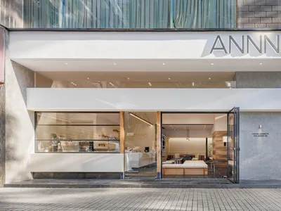 A large open hotel lounge with multiple seating areas, a dining table, and a couch, creating an inviting atmosphere for socializing or dining