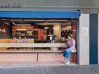 A restaurant dining area with wooden tables and tile elements, featuring patrons enjoying meals and drinks