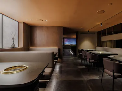 空蕩蕩的棕色內裝餐廳，配有餐桌和椅子，為賓客營造舒適氛圍