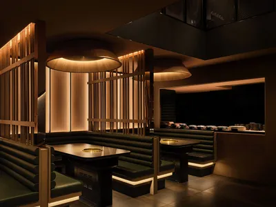 Warm and inviting Asian restaurant interior with wooden tables and chairs, dimly lit for an intimate atmosphere