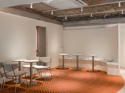 Empty restaurant interior with a circular design on the floor, chairs placed around the dining area, and a clean and well-organized atmosphere