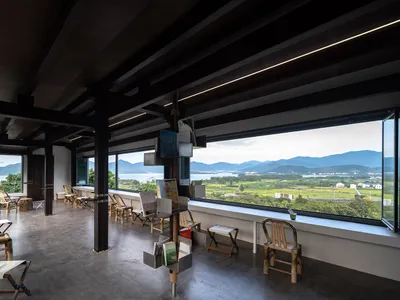 Cozy living space with wooden floors and walls, large windows, and a view of the surrounding mountains