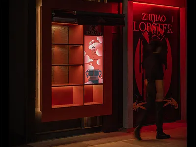 Modern Asian restaurant with red walls, black accents, and a stylish interior, featuring two people in the scene