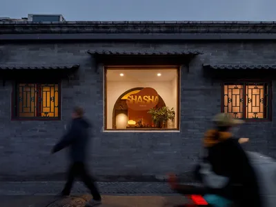 A brick restaurant with a dining table and chairs inside, surrounded by a cozy atmosphere and a potted plant