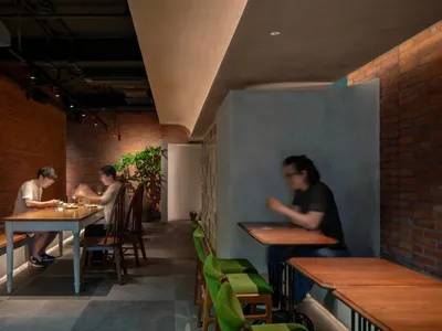 餐廳內部設有數張圓桌與椅子、盆栽植物，以及溫馨誘人的氛圍