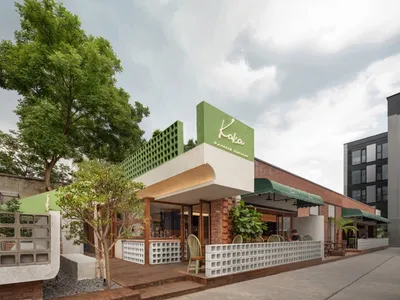 綠色遮陽篷下設有椅子與餐桌的誘人戶外餐廳露台