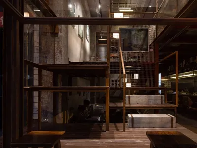 溫馨餐廳室內，附樓梯、木製扶手、長椅與座椅，營造溫暖親切的氛圍