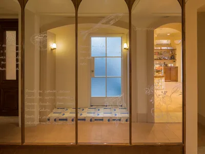 Bathroom interior with wooden walls, two windows, and toiletries on a shelf