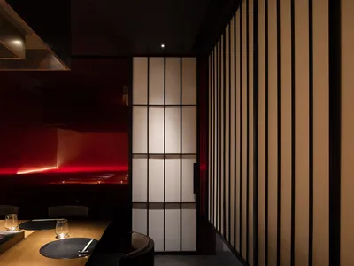 Elegant dining space with wooden furniture, two tables, and chairs, creating a comfortable atmosphere for guests