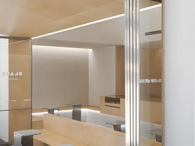 A modern restaurant seating area with wooden benches and tables arranged in rows, providing ample seating options for customers
