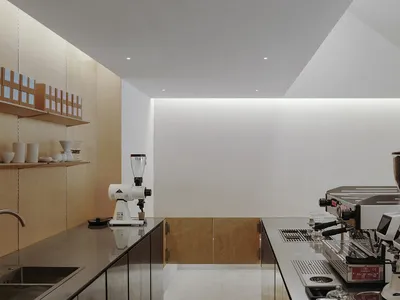 現代白色牆面廚房，配備家電與瓶罐，呈現乾淨明亮的氛圍