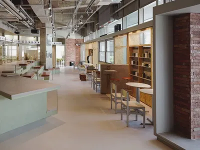 Modern restaurant interior with multiple tables, benches, and artworks on the walls, creating a comfortable and inviting atmosphere