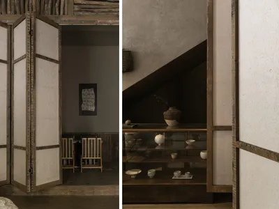 Cozy living space with a dining area, wooden door, and staircase, featuring a glass table, wooden accents, and comfortable seating