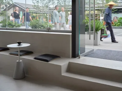 A casual dining area with two benches, a dining table, and potted plants, creating a welcoming atmosphere for socializing