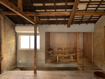 A cozy open concept dining space with a wooden dining table surrounded by four chairs, a metal frame, and inviting atmosphere