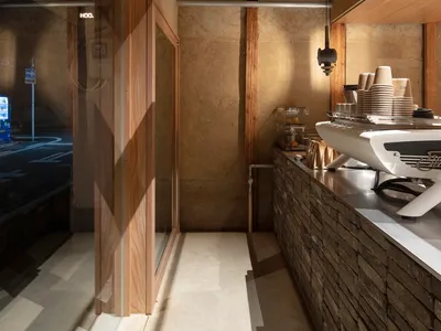 Casual restaurant interior with a counter, dining table, and scattered bowls, featuring a sink in the background