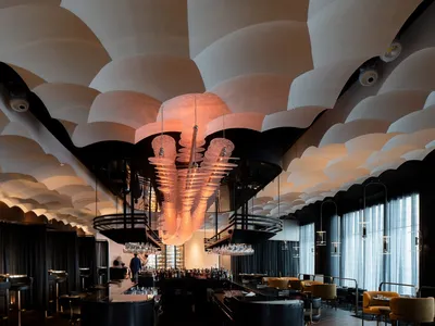 Elegant restaurant interior with a chandelier, wine glasses, and comfortable seating