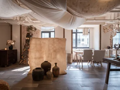 Elegant showroom with decorative vases on a white wall, two chairs, and well-organized display