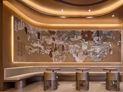 餐廳內部有一幅大型地圖壁畫，描繪人物、馬匹、樹木與建築，周圍環繞座椅與兩張餐桌，營造溫暖親切的氛圍