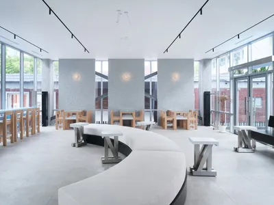 Open restaurant interior with modern design, multiple tables, benches, and warm ambient lighting