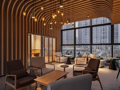 Warm and inviting open concept living area with a large wooden beam, multiple chairs, a dining table, and a potted plant