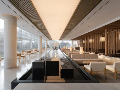 Sophisticated hotel lobby with black marble tables, chairs, and couches, creating a luxurious atmosphere with refined ambiance