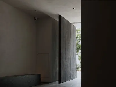 Dimly lit hallway with concrete floor, two doors on either side, and a quiet atmosphere