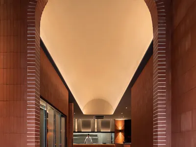 溫暖親切的餐廳內部，磚牆、大型用餐區，背景有廚房