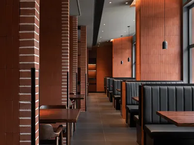 磚牆溫暖餐廳內部，木桌椅營造舒適的用餐氛圍